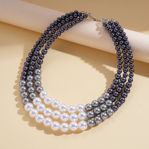 Detailed view of the triple-layer pearl necklace with a gray gradient and metal clasp