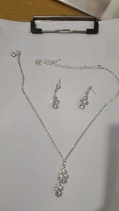 Detailed view of silver zircon flower necklace and tassel earrings with adjustable chain