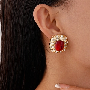 Gros plan détaillé de boucles d'oreilles vintage dorées avec pierre rouge et strass