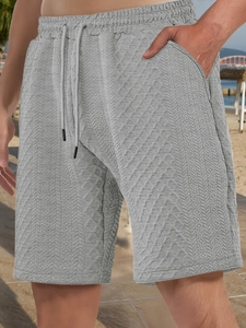 Detail of grey men's casual shorts featuring textured fabric and drawstring waist