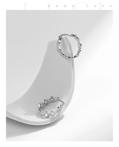 Gros plan des boucles d'oreilles Mobius en argent S925 avec zirconiums sur socle blanc