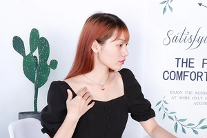 Detailed view of a woman wearing a red crystal ball pendant on a silver chain