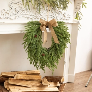 Détail d'une couronne de Noël artificielle avec pommes de pin et nœud en toile