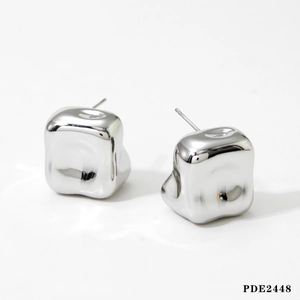 Détail macro de boucles d'oreilles carrées irrégulières en argent style métal liquide