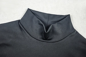 Close-up of a black high-neck mesh dress showing refined knit texture and mock neckline