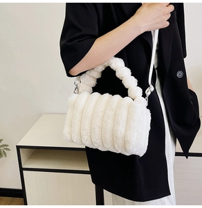 Detail of white plush handbag with textured stripes and bubble handle on black blazer