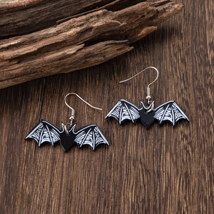 Gothic black and white bat wing earrings on dark wood background for Halloween style