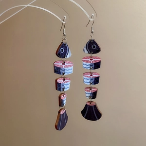 Close-up of ethnic wood fish bone pendant earrings with realistic printed texture