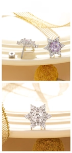 Macro shot of snowflake zircon screw back earrings in purple and white plating