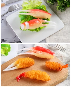 Detailed close-up of realistic tempura shrimp and crab claw models on a wooden board