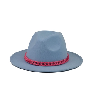 Detail of light blue fedora hat with a bold contrast pink resin chain accessory