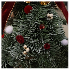 Detailed macro view of green pine needles with red velvet ribbon and berry Christmas decor