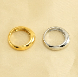 Minimalist gold and silver irregular rings displayed on a luxurious yellow silk surface
