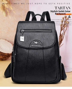 Detail of black litchi texture synthetic leather backpack with metallic brand plate