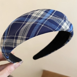 Detailed macro view of the blue and white plaid fabric texture on a wide headband