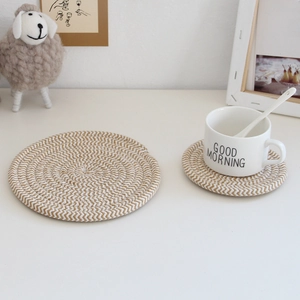 Close-up of woven cotton rope coasters in beige and white for heat-resistant table protection