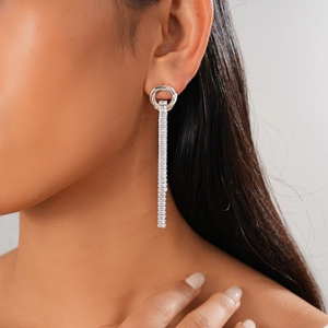 Detail of silver drop earring with round stud and zircon rectangular tassel on model