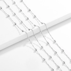 Macro shot of silver stainless steel water wave chain with beads for DIY jewelry making