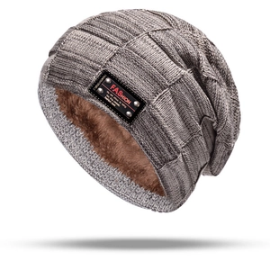 Detail of dark grey knit hat showing thick brown faux fur lining and fashion patch