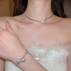 Close-up of a silver fashion jewelry set with shimmering crystals and large pearls