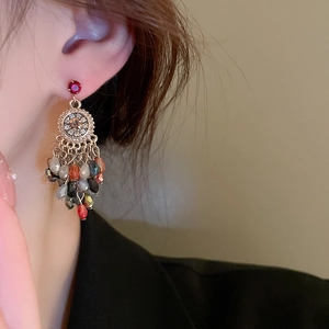 Macro detail of bohemian flower earrings with crystal tassels and colorful beads