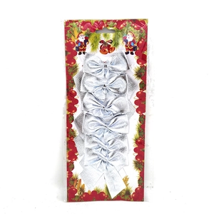 Detail view of six silver sequined Christmas tree bows on a decorative card package