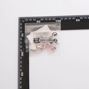 Pink heart and star bead metal earrings measured with a black ruler on a white background