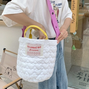 Sac à main blanc matelassé avec coutures en cœur, poignées jaunes et bandoulière mauve