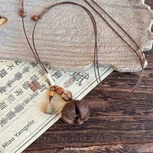 Detailed close-up of a rustic ethnic necklace with wood beads and seed pod pendant