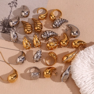 Flat lay view of teardrop earrings and gold jewelry collection on minimalist background