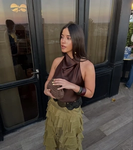 Détail du haut dos nu en satin avec jupe à volants vert olive et accessoires de mode