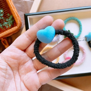 Dettaglio dell'elastico per capelli nero con ciondolo a cuore blu floccato