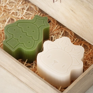 Gros plan de moules en silicone sapin et renne dans un coffret en bois