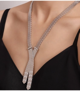 Detail of silver plated stainless steel woven chain necklace with geometric pendant on model