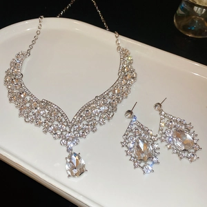 Macro shot of silver teardrop necklace and earring set with shimmering cubic zirconia