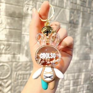 Detail of a liquid-filled acrylic rabbit keychain with glitters and a golden bell
