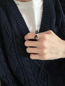 Detail of a minimalist bow-knot ring with black beads on a silver-tone band