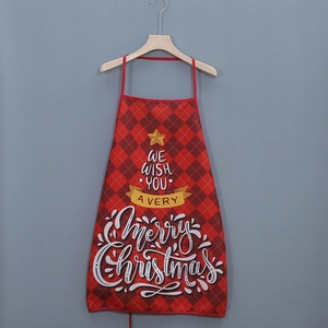 Close-up of red plaid Christmas apron with Merry Christmas print on a hanger