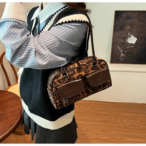 Close-up of leopard print shoulder bag with brown patent leather pockets and gold hardware
