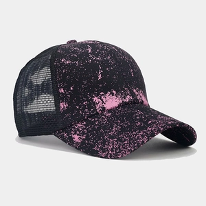 Detail view of pink splatter print on a breathable mesh ponytail baseball cap for women
