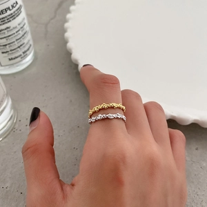 Close-up of gold and silver S925 rings with irregular bubble texture on model fingers