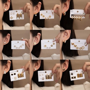Detail shot of assorted stainless steel gold earrings with clover and heart motifs