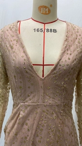 Detail of deep V-neck and sparkling gold sequins on long-sleeve pink party dress