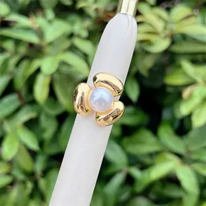Detail of 18K gold plated three-petal flower ring with central white pearl inlay