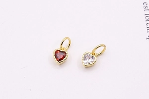 Detail of heart-shaped pendants with red and clear zircons in gold-plated frames