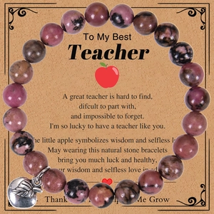 Close-up of pink zebra stone beads and silver apple pendant on a gratitude gift card