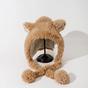 Detail of plush lamb wool lining and large pom-pom ties on brown animal ear hat