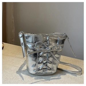 Gros plan du sac seau argenté avec texture plissée tendance et détail de nœud élégant