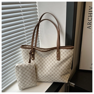 Detail view of large retro tote bag with monogram print and matching pouch accessory