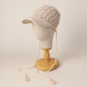 Detail of hand-crocheted hollow mesh sun hat with stylish tassel drawstrings